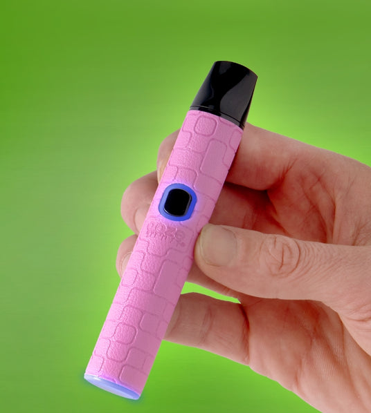 Pink Pinch vape pen held in a hand with lights turned on, against a green background
