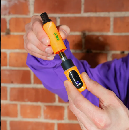 Orange Hivo device held by a person against a brick wall