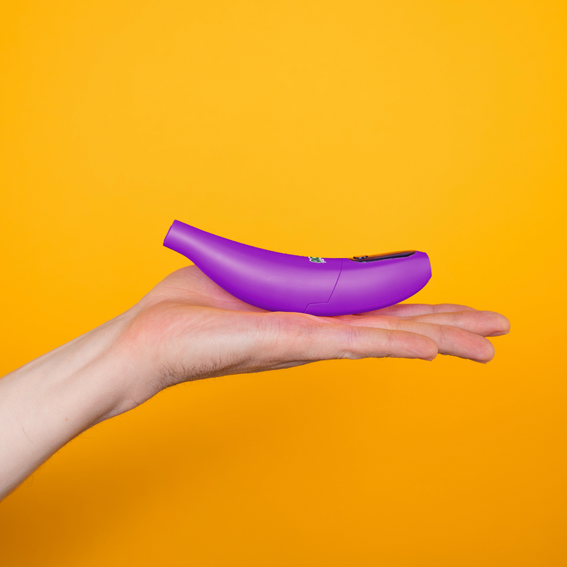Purple Peel banana battery held in a hand against an orange background