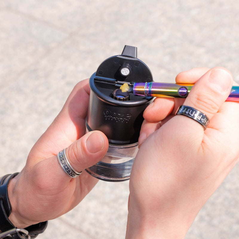 Loading a dab into a black Electro Barrel e-rig with a twist hot knife
