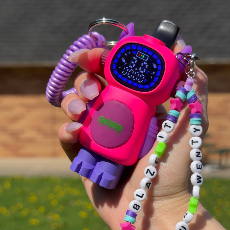Holding a pink personalized Bot vape outside with the screen turned on