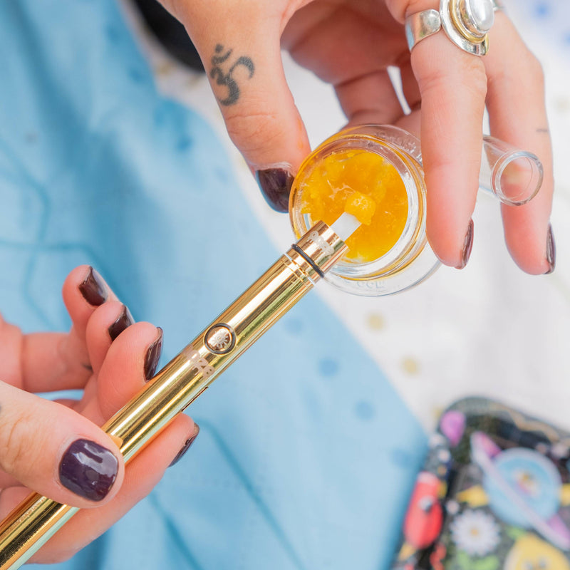 Using a gold Twist Hot Knife to pick up a dab from a jar of wax