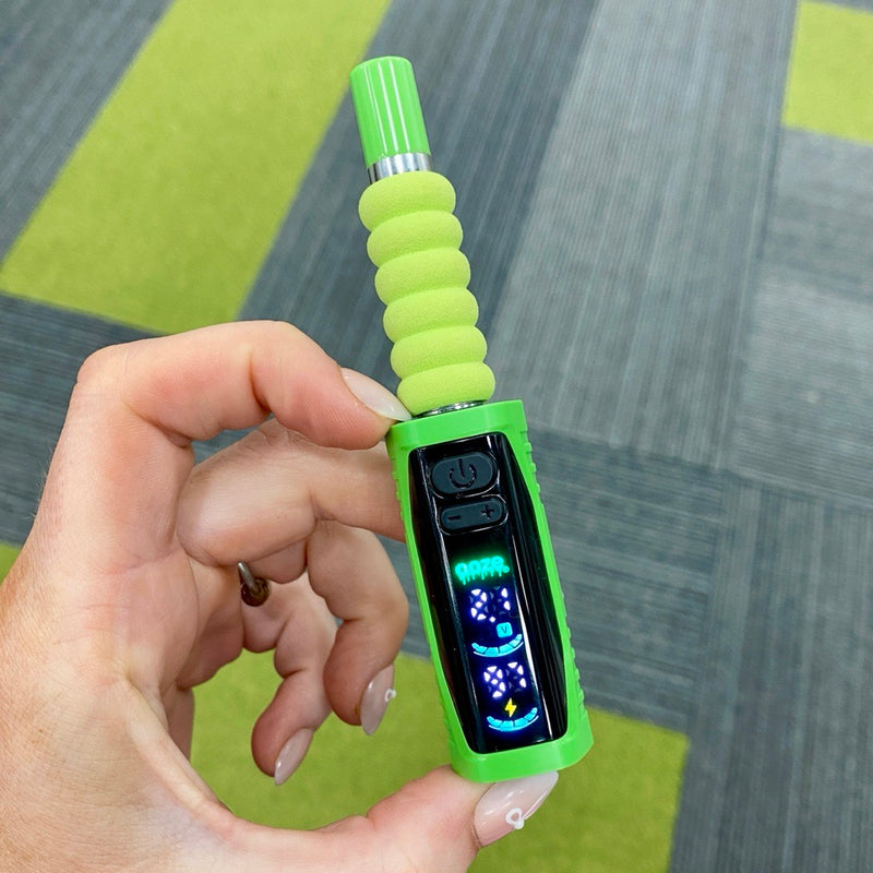 Close up of a person pinching the green Ooze Runt Mini Battery to show how small it is, with the screen turned on and cartridge connected