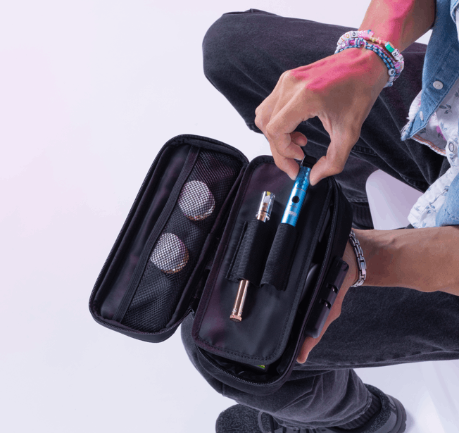 Looking down at a guy taking his blue Beacon out of his Ooze smell proof travel kit. He also has a Twist Hot Knife and 2 jars of OozeX concentrates in the pouch.