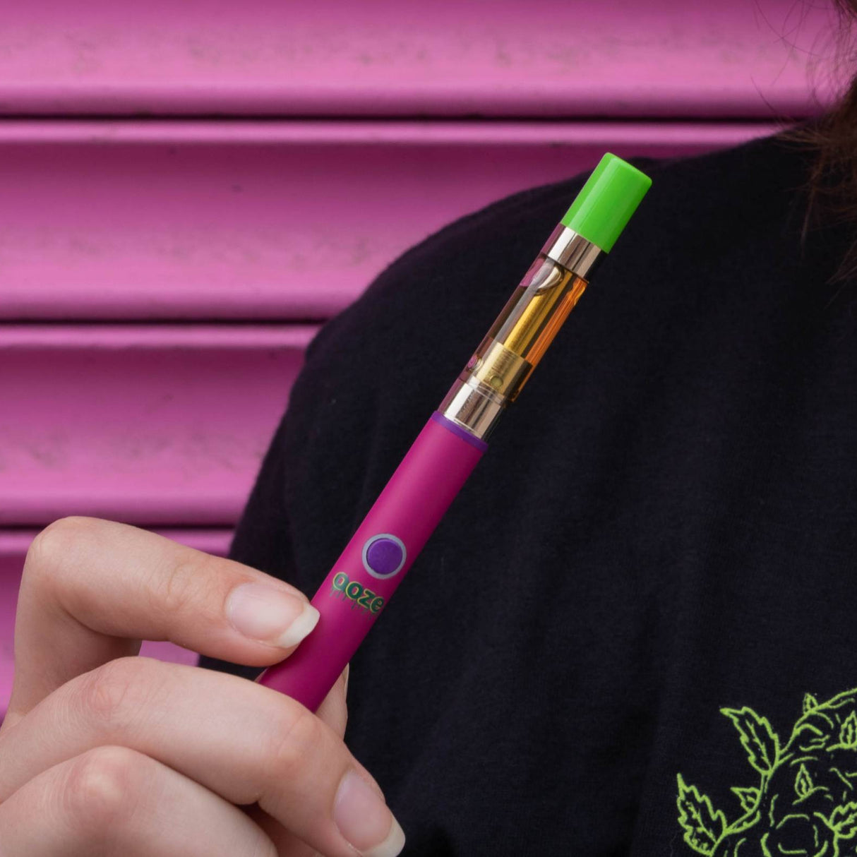 Holding a pink Twist Slim Pen 2.0 vape battery
