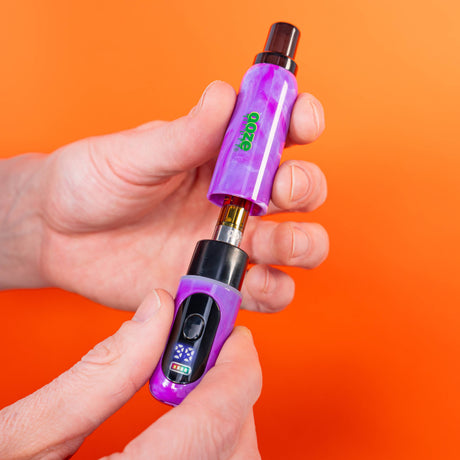 Holding purple Hilo battery pulling off the cap to show cart inside