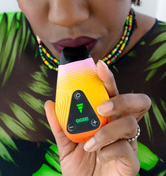 Person smoking out of Brink pink and yellow weed pen