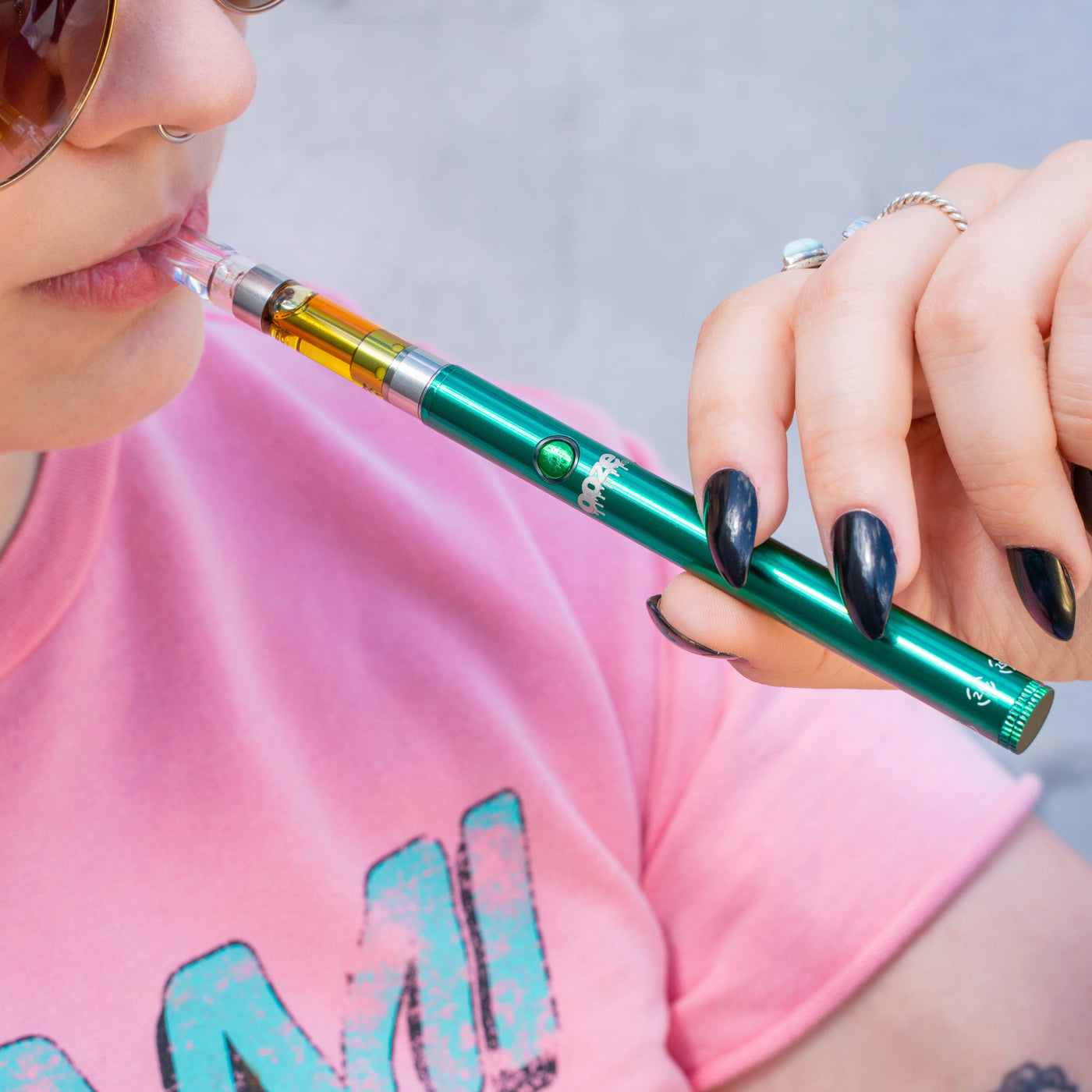 Taking a puff from an aqua teal Twist Slim Pen 2.0