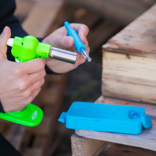 Using a green torch to heat the dab straw of the blue Ooze Slugger silicone dab dugout