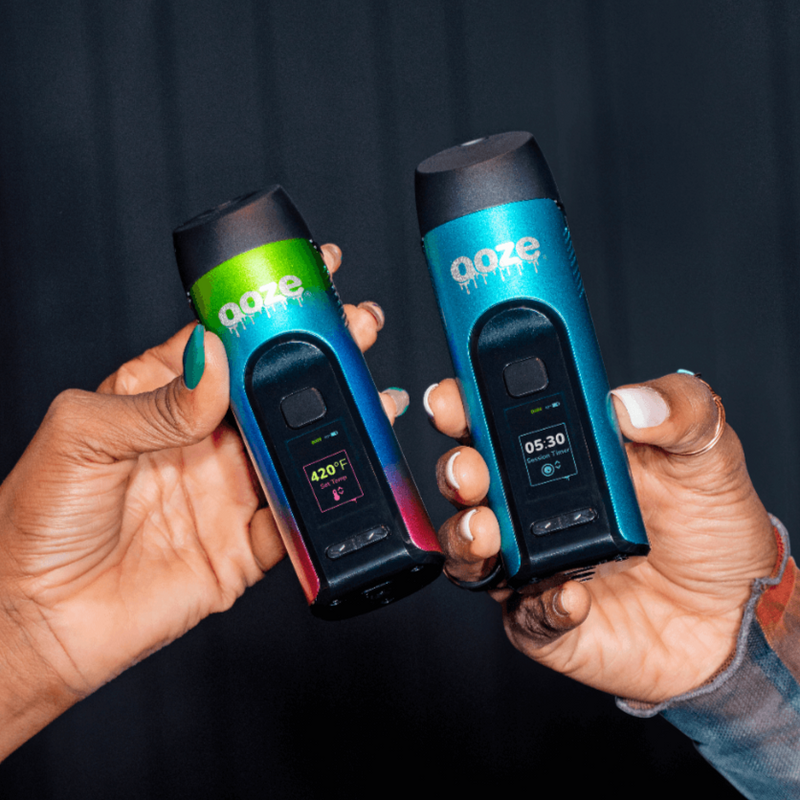 Person holding up Blue Verge cannabis vape and Rainbow Verge Cannabis vape