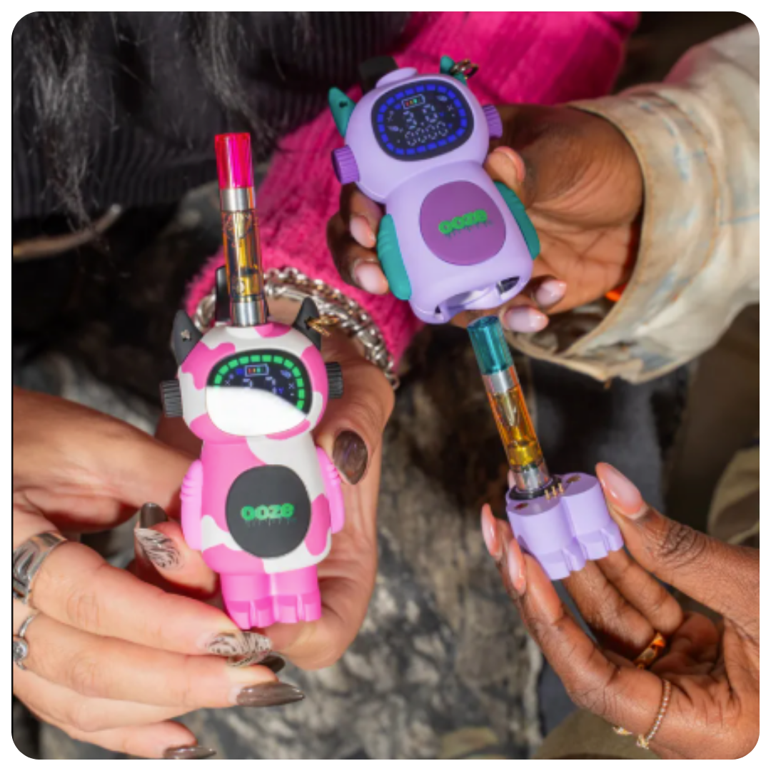 Two colorful Bot vape devices shaped like little robots held by hands.