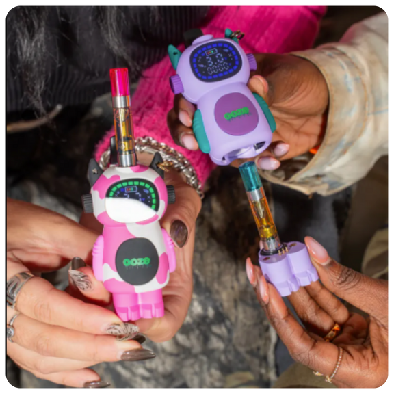 Two colorful Bot vape devices shaped like little robots held by hands.