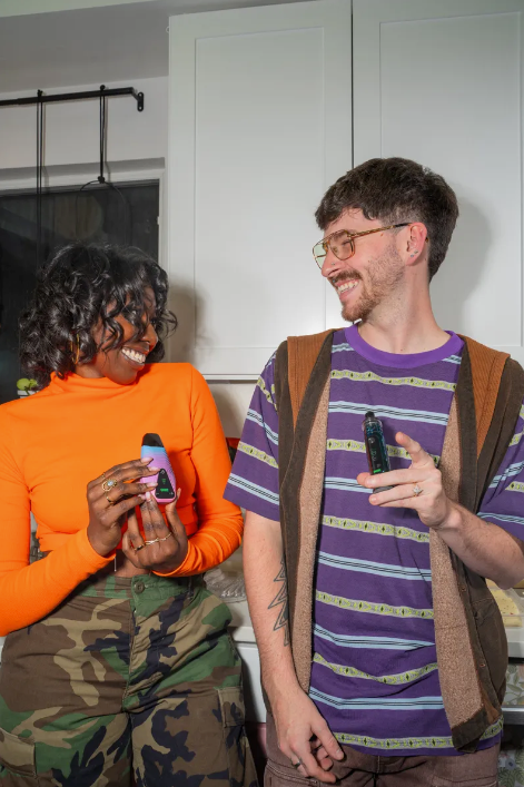 Two people smiling and holding Ooze products