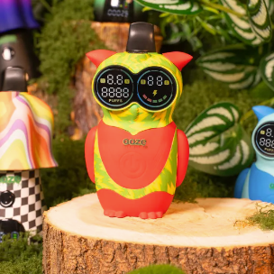Colorful owl-shaped device with digital display on a wooden stump against a natural background