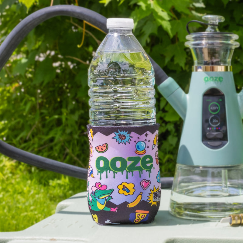 The Ooze Hotel Lucky slim can koozie is shown on a water bottle outside with a Ripley dab rig hookah in the background