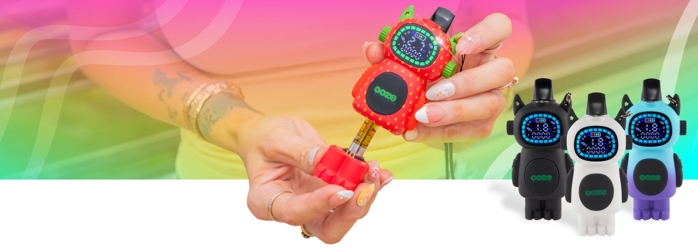 A person holds a strawberry Bot vape with the feet pulled out, next to a black, white, and moonrise Bot standing to the right.