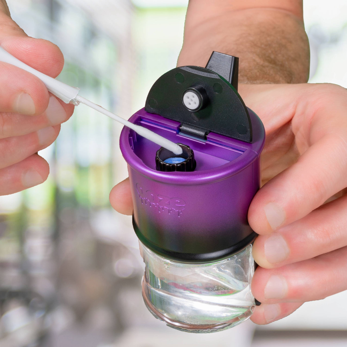 Using an Ooze Resolution Micro Swab to clean the onyx atomizer of a galaxy purple Ooze Electro Barrel