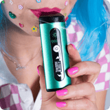 Person taking a puff from green Drought dry herb vape