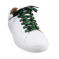 The black Ooze Shoelaces are laced into a plain white sneaker and tied in a bow