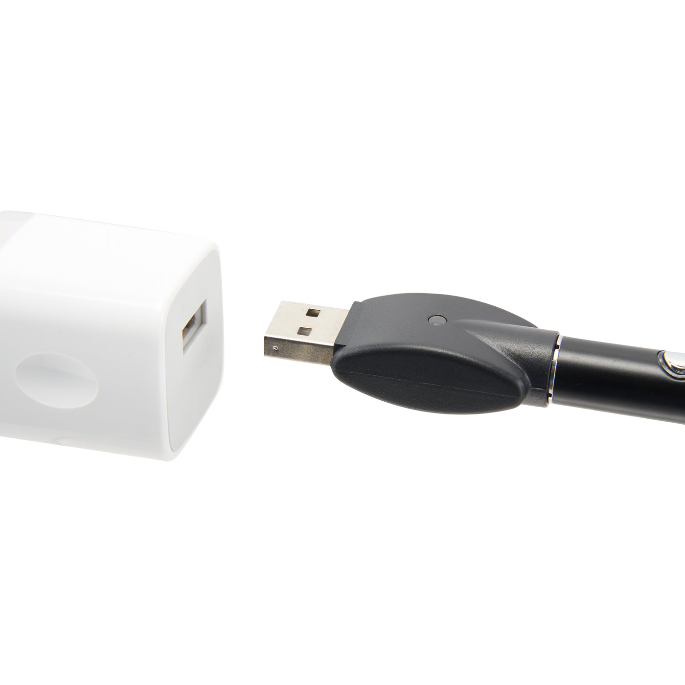 The black Ooze Wink flashlight vape pen is plugged into the 510 charger and is being plugged into a white USB wall adapter 