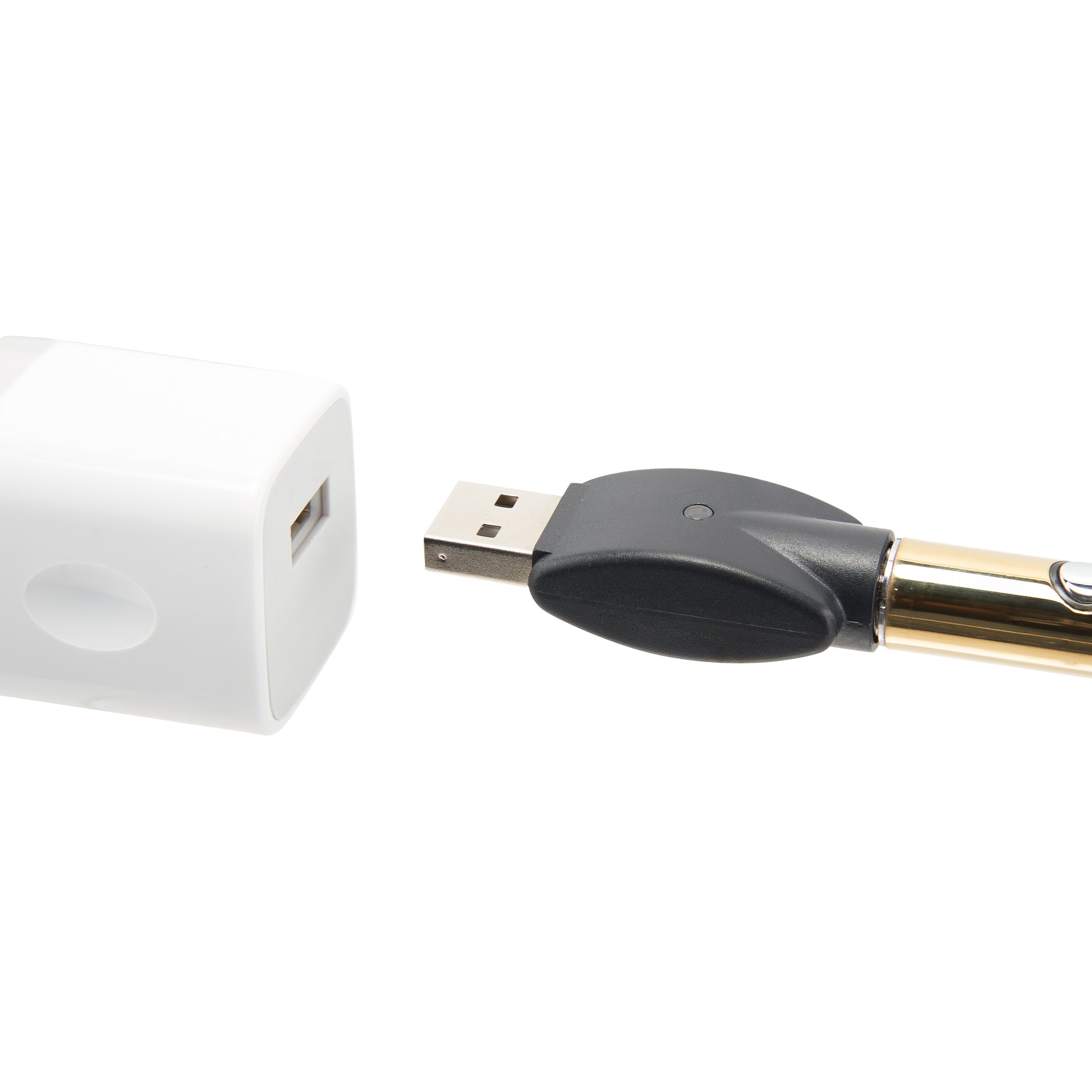 The gold Ooze Wink LED vape pen is plugged into the 510 charger, being plugged into a white square USB wall adapter