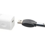 The chrome Ooze Wink is plugged into its 510 charger, being plugged into a white square USB wall adapter