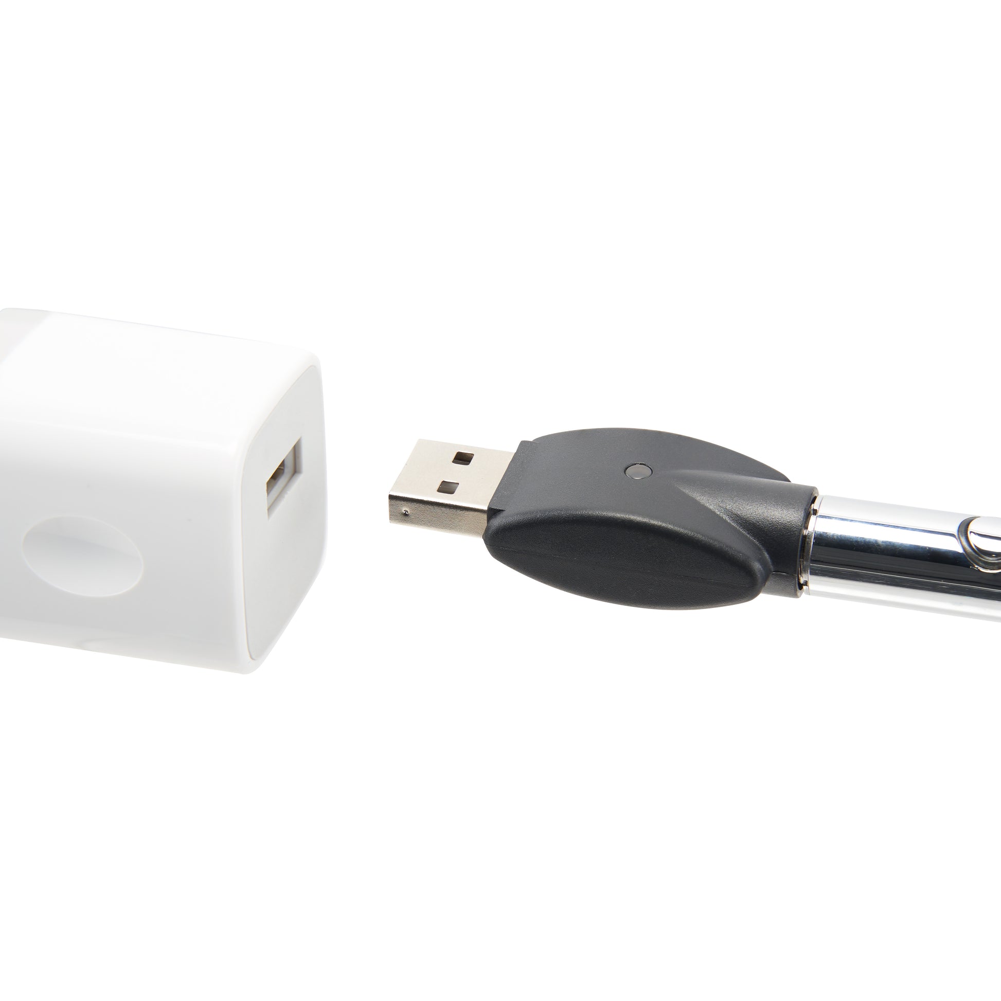 The chrome Ooze Wink is plugged into its 510 charger, being plugged into a white square USB wall adapter