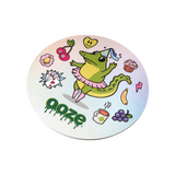 Angled view of the Cardboard Hotel Lucky coaster with the dancing alligator and other lucky charms