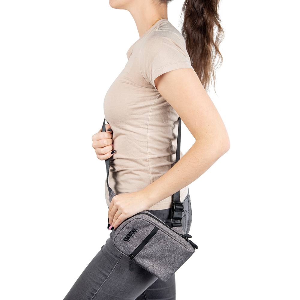 A girl wearing the grey Ooze crossbody bag at her hip with the strap extended