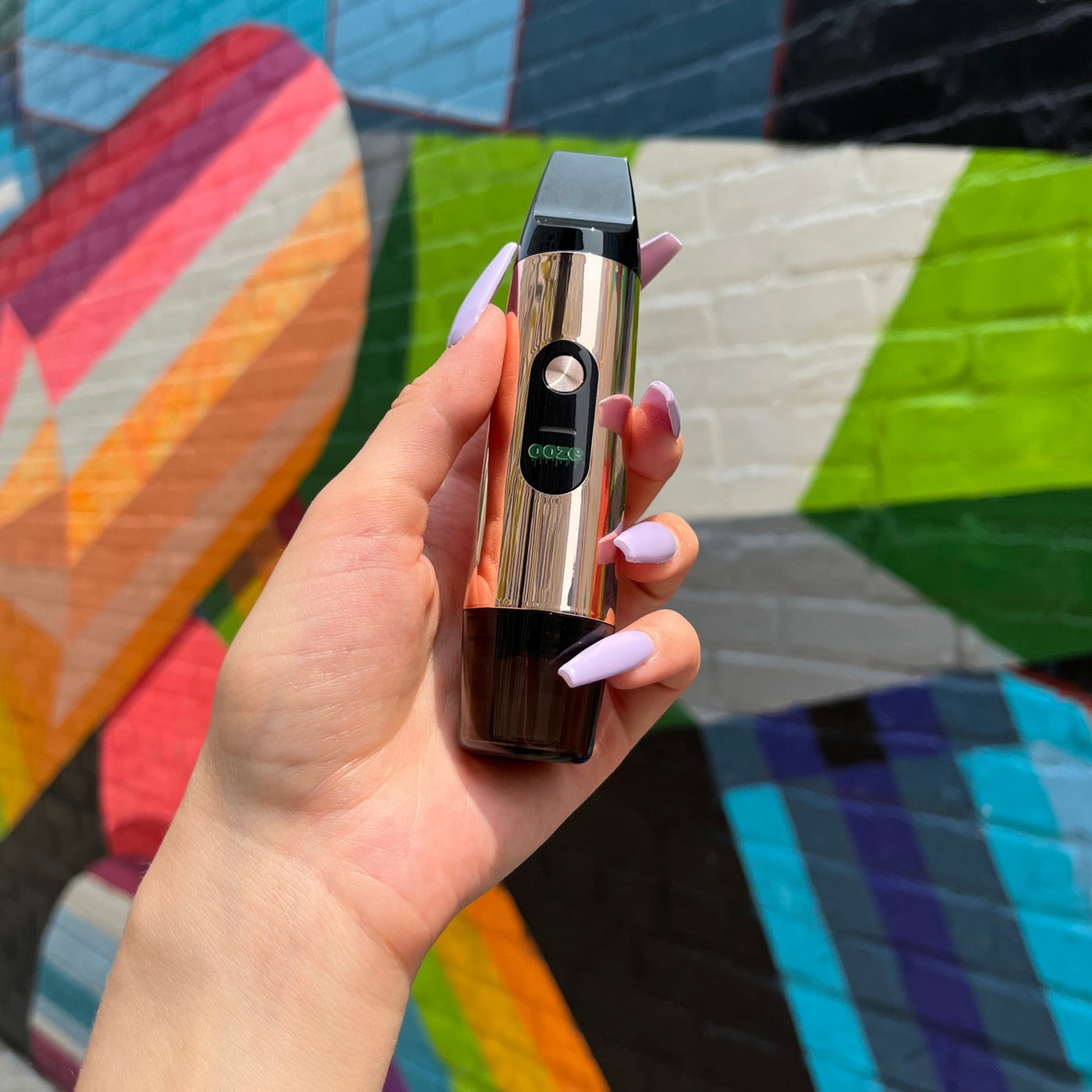 Person holding Rose Gold Booster extract vape
