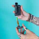 Pulling the base out of a black Duplex 2 vaporizer to show the cart