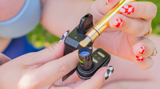 Loading a dab into a black Duplex 2 vaporizer using an Ooze hot knife