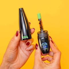 Person holding black Peel banana battery in two hands: cap in one and base with cartridge in the other
