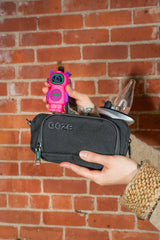 Holding an Atomic pink Ooze Bot character vape battery above a travel pouch
