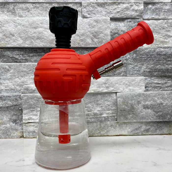 The red Ooze Blaster silicone bong has the black armor bowl inserted and is filled with water