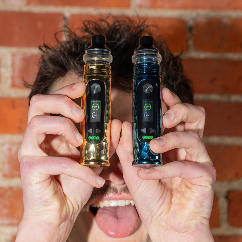 Holding up blue and Gold Titan Extract Mods and sticking tongue out