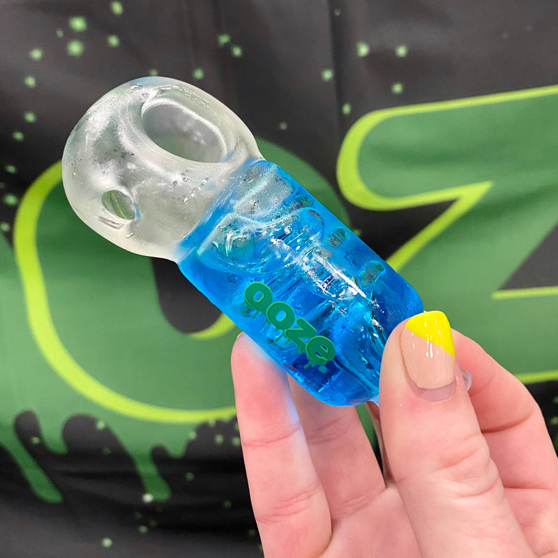 Person holding blue ooze cryo bowl in front of an Ooze flag