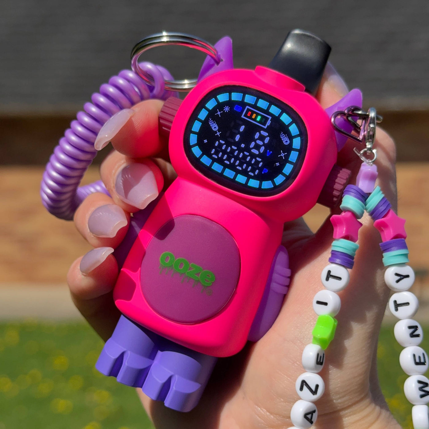 Holding a personalized pink Bot character vape with the screen on outside