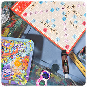 Ooze Rolling Tray, Ooze Bot Character Vape, and Ooze Booster Extract Vape on a table at game night.