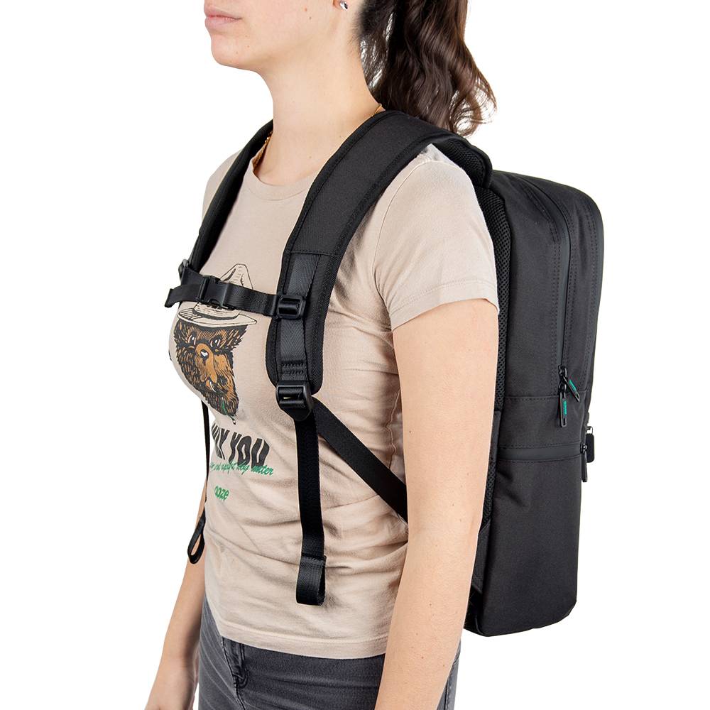 A girl wearing the black Ooze backpack with the straps buckled across her chest