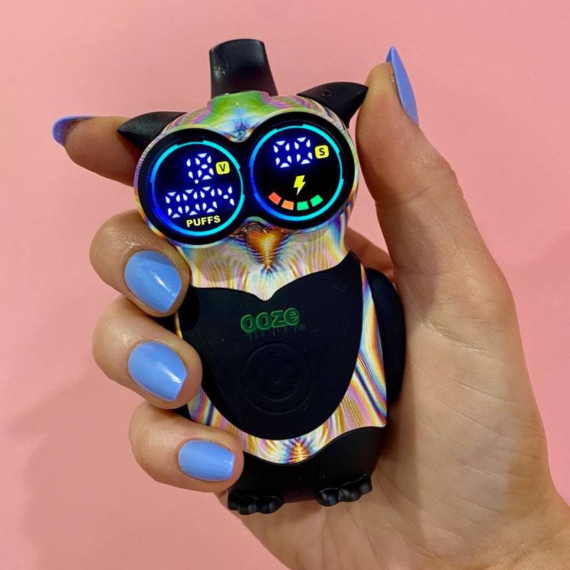 Glitch Ooze Hoot owl vape battery held in front of pink background