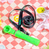 Green Piper with black lanyard laying on checkered blanket