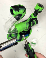 Heating the titanium dab straw tip of the Ooze green and black Swerve silicone pipe, in front of the rest of the rig