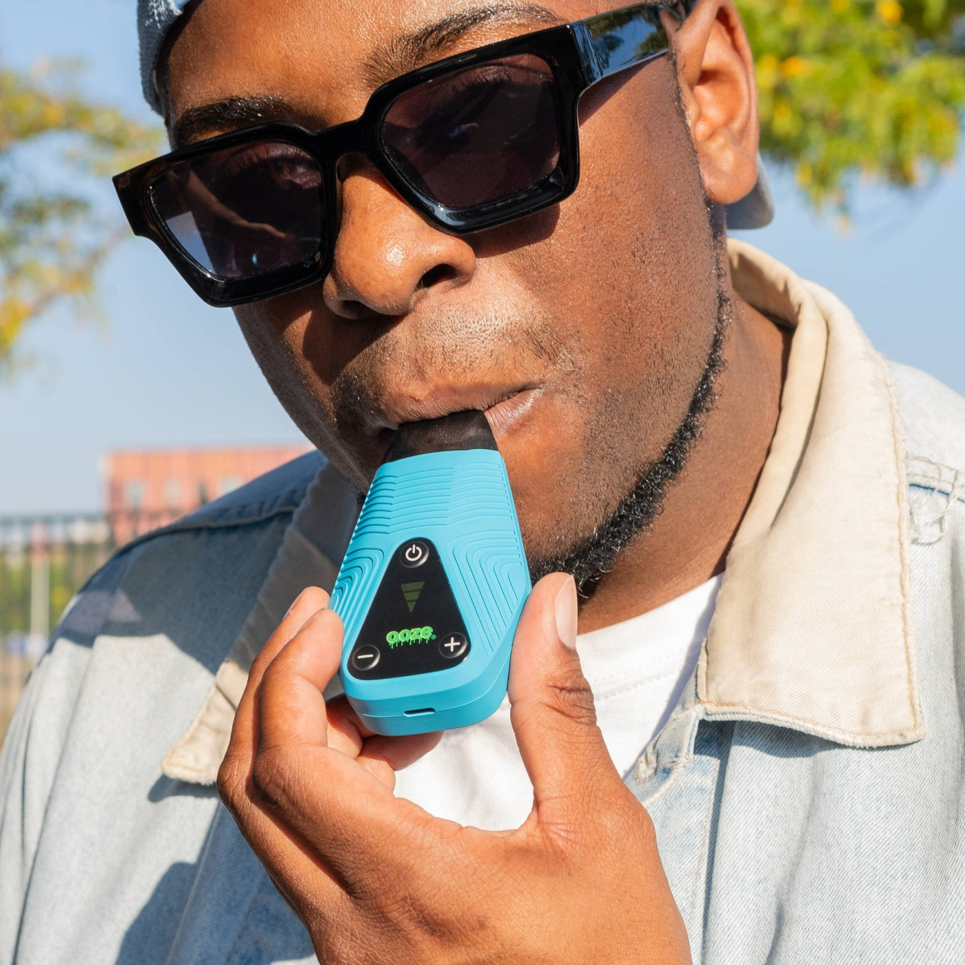 Taking a puff from the sapphire blue Brink dry herb vape