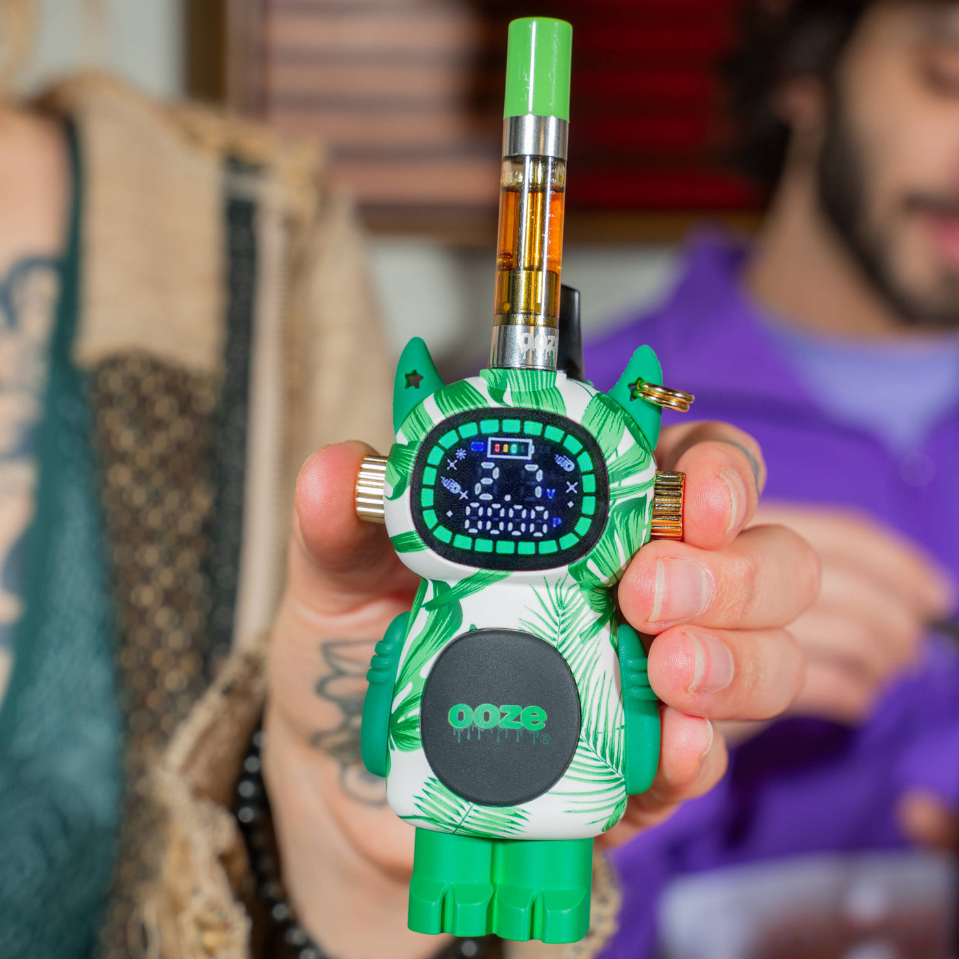 Holding a House Plant Ooze Bot character vape battery with a cart attached to his head