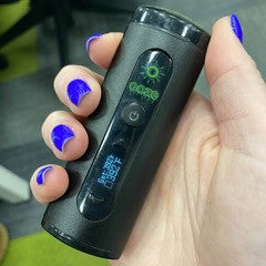 Person holding a black Drought dry herb vape