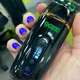Person holding a black Ooze Flare vape with the screen turned on