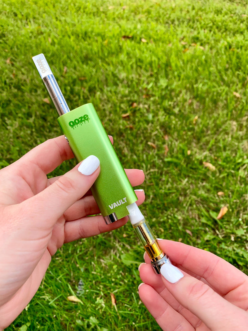 Removing a 510 cart from the hidden compartment of a green Vault battery