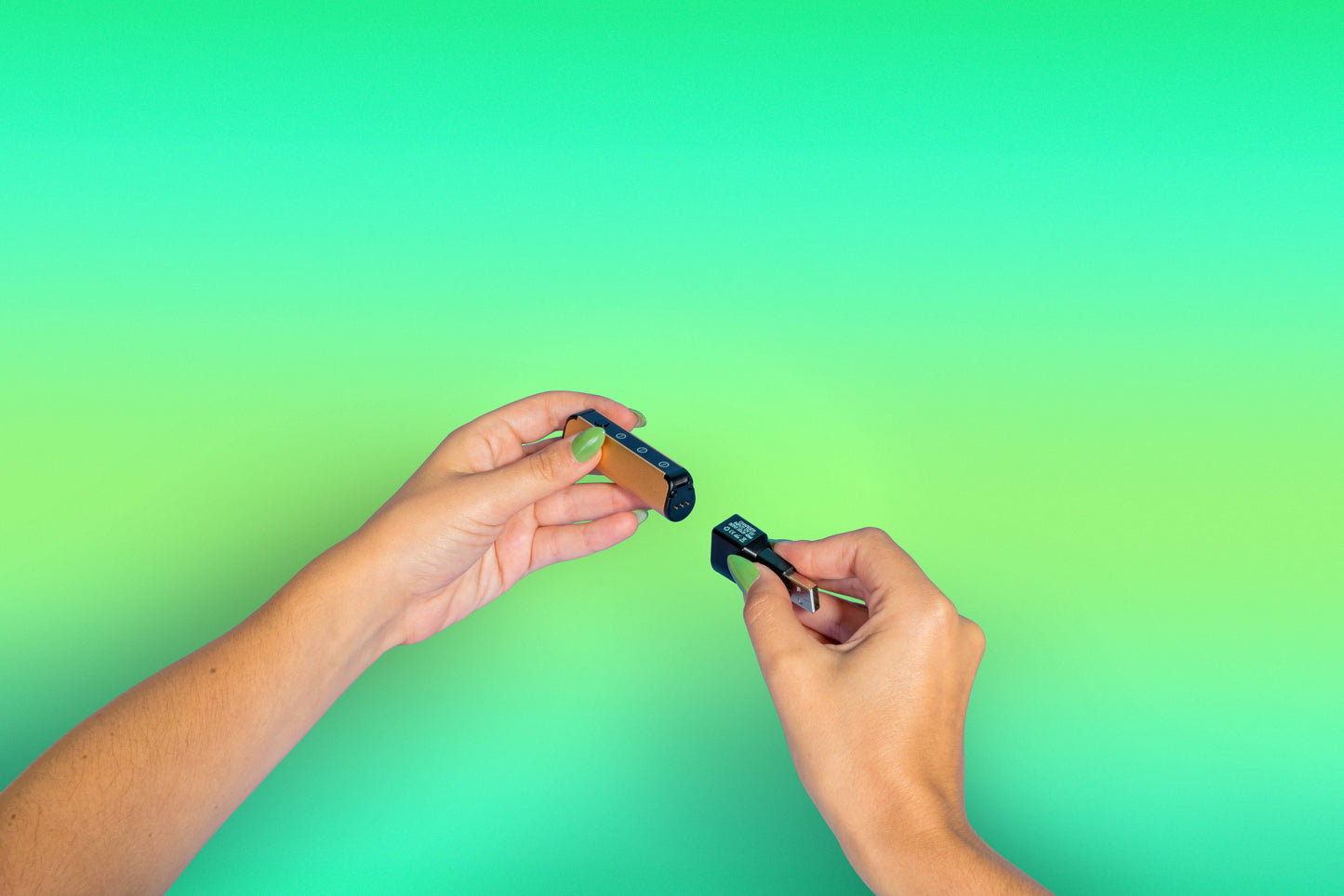 A girl with green nails connects the magnetic charger to the base of an Ooze Novex