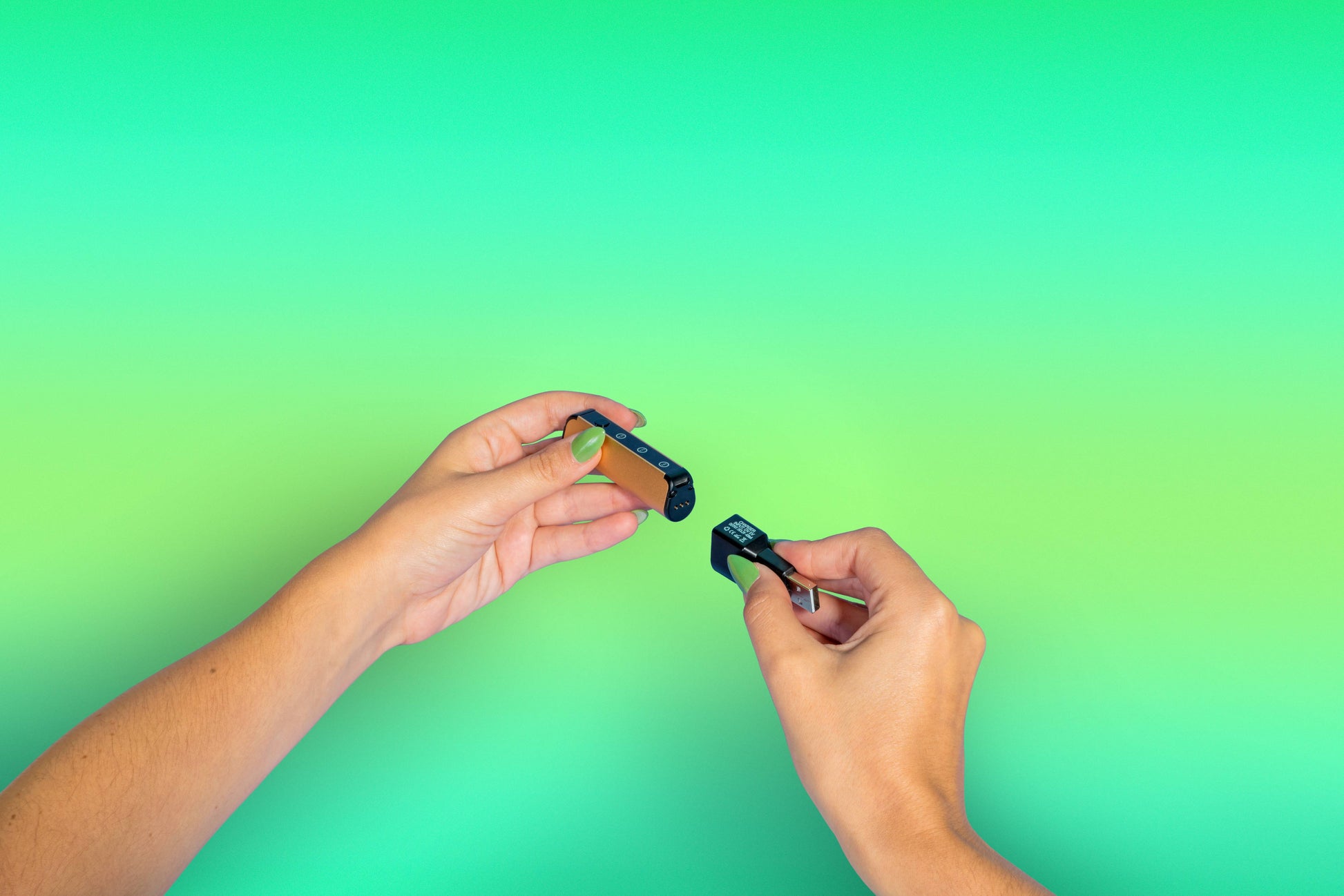 A girl with green nails attaches the magnetic charger to the base of an Ooze Novex